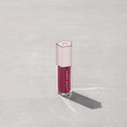 Marom Fenty Beauty Gloss Bomb Universal Lip Luminizer in a deep berry shade with a hexagonal cap