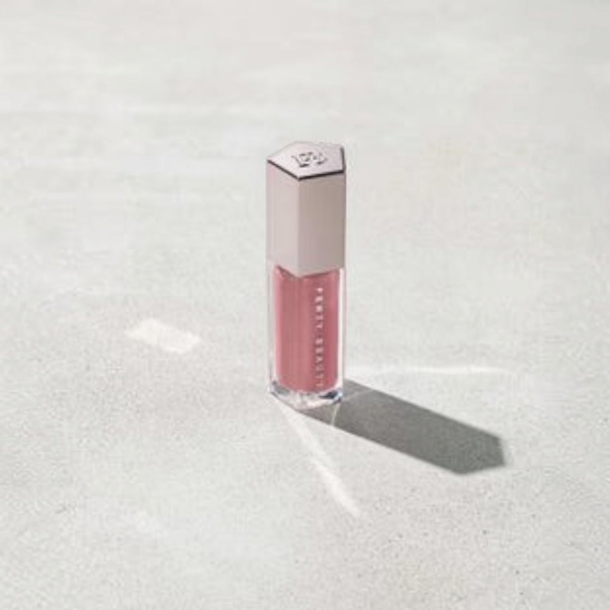 Marom Fenty Beauty Gloss Bomb Universal Lip Luminizer in a rose-tinted shade with a metallic hexagonal cap