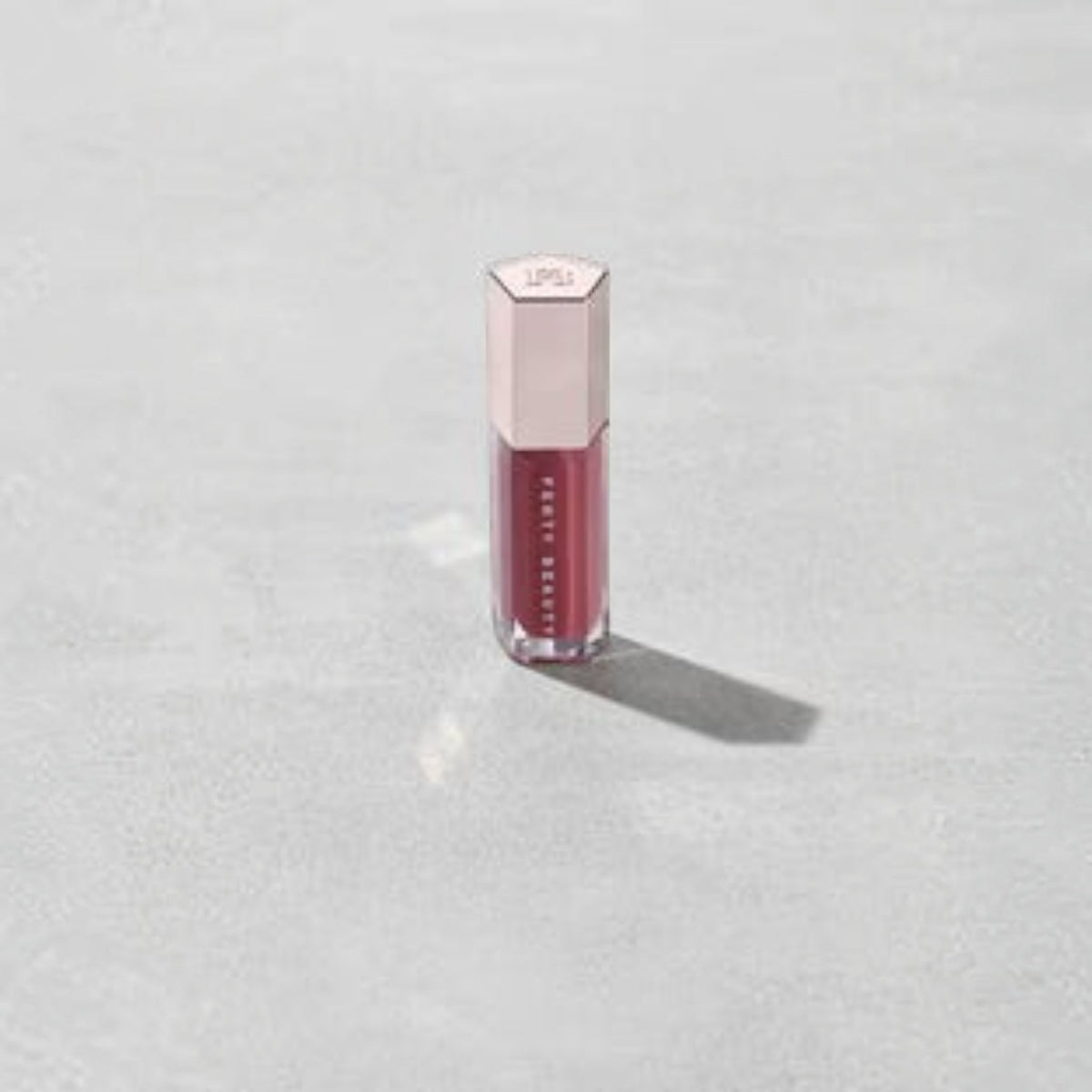 Marom Fenty Beauty Gloss Bomb Universal Lip Luminizer in a berry shade with a metallic hexagonal cap