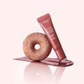 Marom LANEIGE Glaze Craze Tinted Lip Serum in Cinnamon Sugar shade with a sugary donut on a pink background