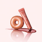 Marom LANEIGE Glaze Craze tinted lip serum in Maple Glaze shade next to a glazed donut on a soft pink background