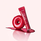 Marom LANEIGE Glaze Craze Tinted Lip Serum in Raspberry Jam shade next to a glossy red donut on a pink background