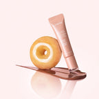 Marom LANEIGE Glaze Craze tinted lip serum tube with a donut and a glossy brown product swatch on a pink background