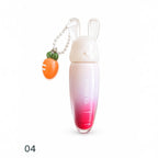 Marom Olibolla glossy lip tint in a carrot-shaped tube with a white bunny cap and a small carrot charm