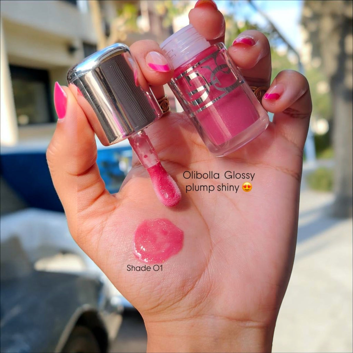 Marom Olibolla Glossy Lip Tint in shade 01, a vibrant pink liquid lip product with a glossy finish on a hand swatch.