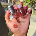Marom Olibolla Glossy Lip Tint in shade 02, a shimmering brown liquid lipstick with a doe-foot applicator on hand.