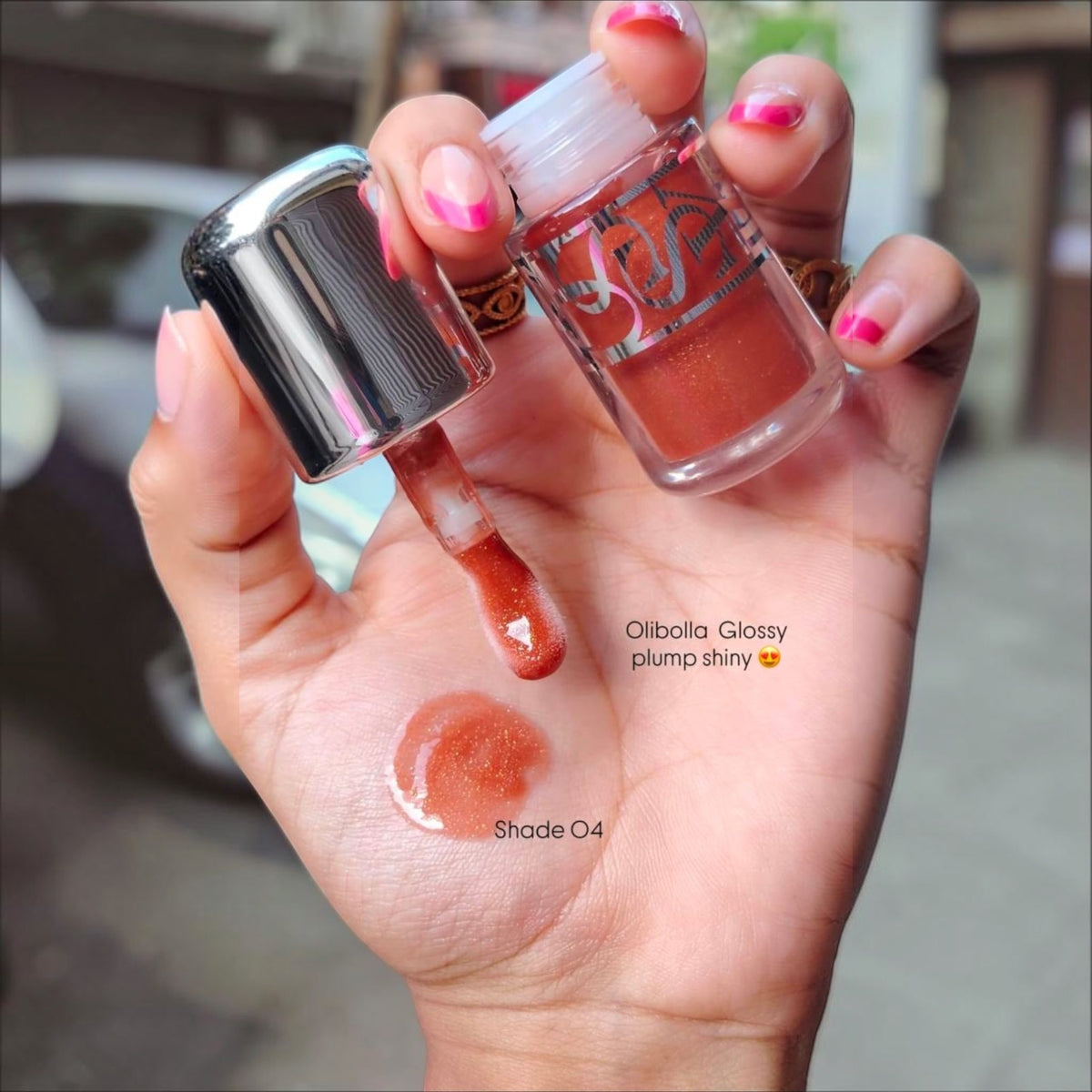 Marom Olibolla Glossy Lip Tint in shade 04, a shimmering coral-toned liquid lip product with a glossy finish.