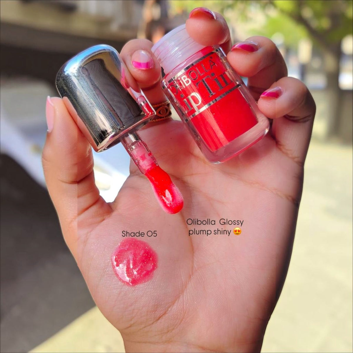 Marom Olibolla Glossy Lip Tint in shade 05, showing a vibrant red liquid texture swatched on a hand with applicator.