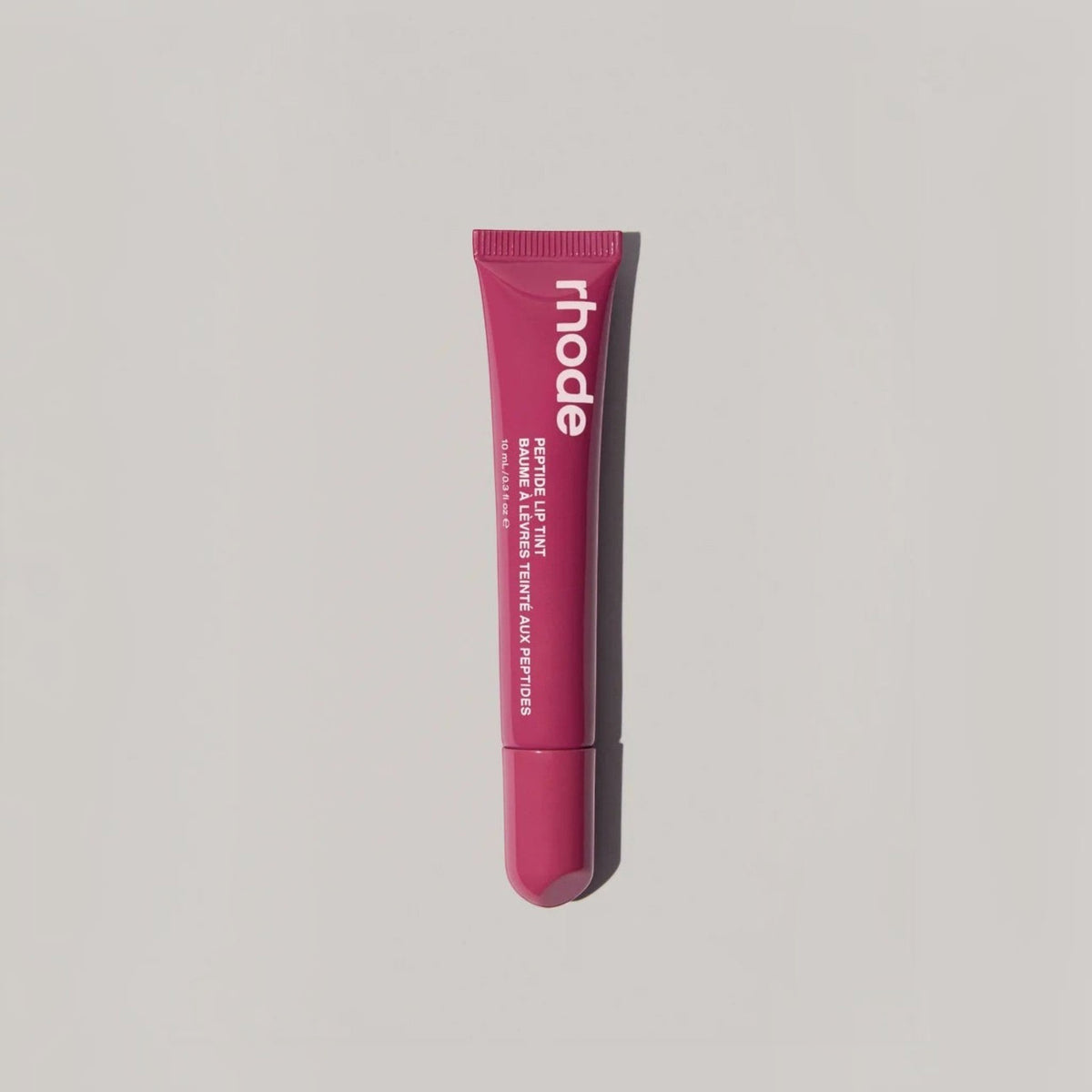 Marom rhode Peptide Lip Tint in a deep berry shade, a restorative and hydrating lip treatment in a squeeze tube.
