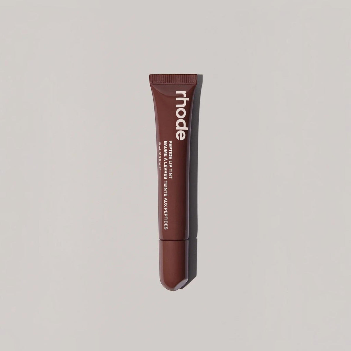 Marom rhode Peptide Lip Tint in a dark brown squeeze tube for hydrated, glossy lips.