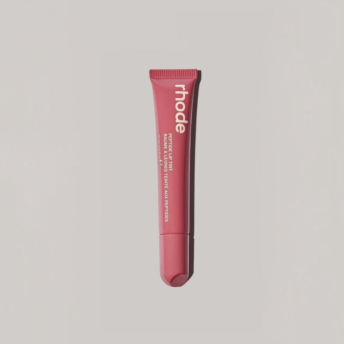 Marom rhode Peptide Lip Tint in a pink squeeze tube for hydrating and nourishing lips with a sheer glossy finish.