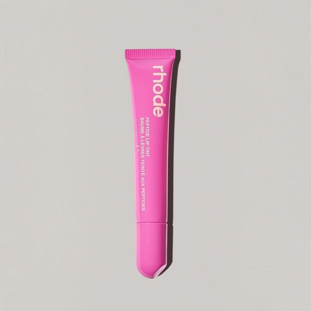 Marom rhode Peptide Lip Tint in a vibrant pink squeeze tube for hydrated, glossy lips.