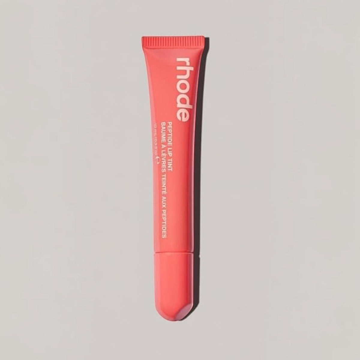 Marom rhode Peptide Lip Tint in a coral-toned squeeze tube for hydrating and glossy lip care.