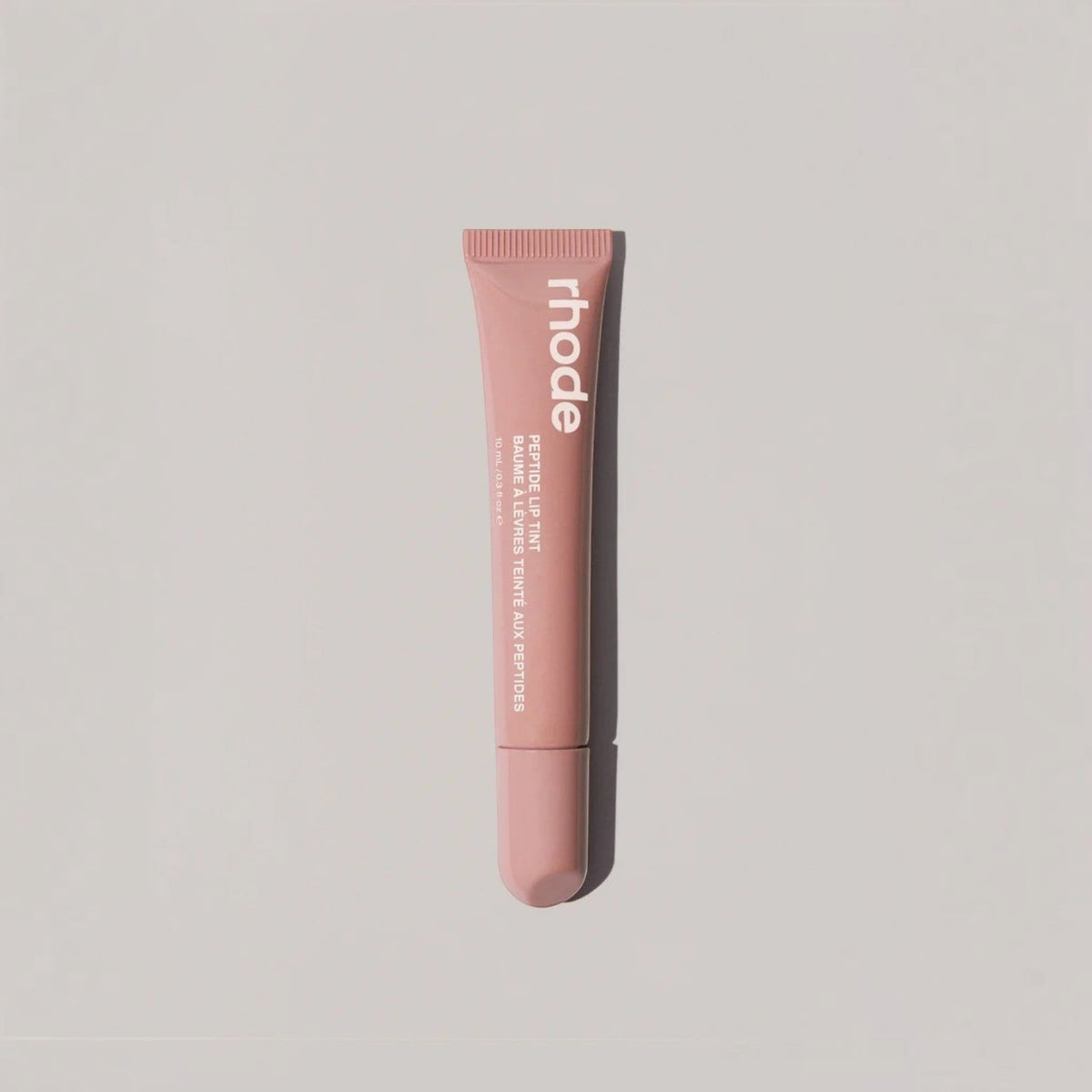 Marom rhode Peptide Lip Tint in a muted pink squeeze tube for hydrating and conditioning lips with a glossy finish.